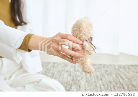Woman playing with her dog in the living room 122795558