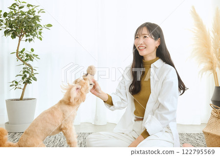 女人在客廳和她的狗玩耍 女人在客廳和她的狗玩耍 122795569