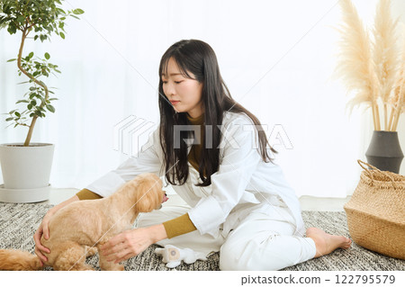女人在客廳和她的狗玩耍 122795579