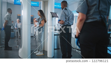 Family with Two Kids Passing Through Metal Detector Scanner. Security Officer Checks Passenger on Tablet 122796121