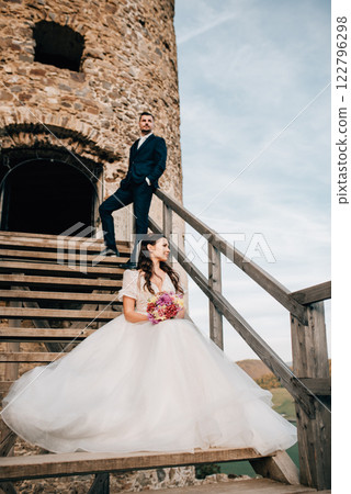 Portrait of beautiful wedding couple standing outside near ruins. 122796298