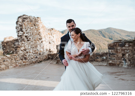 Portrait of beautiful wedding couple standing outside near ruins. 122796316