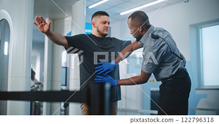 Security Officers Inspecting Adult Man with Metal Detector Scanner for Flight, Finding Mobile Phone Security Officers Inspecting Adult Man with Metal Detector Scanner for Flight, Finding Mobile Phone 122796318