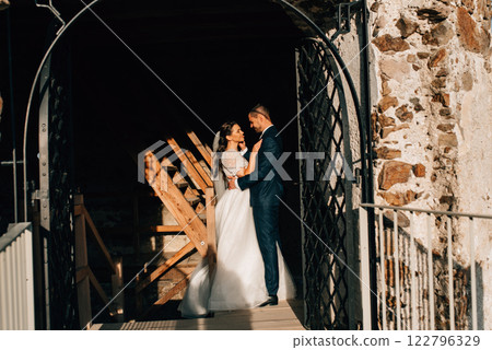 Portrait of beautiful wedding couple standing under big gate. 122796329