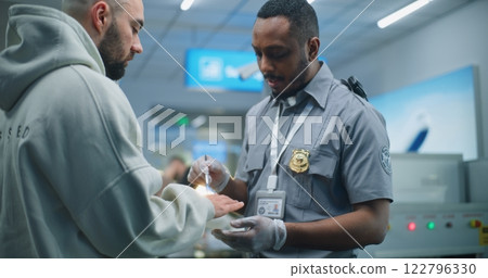 Security Officer Conducts ETD Procedure with Brush to Adult Man for Plane Flight 122796330