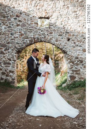 Portrait of beautiful wedding couple standing outside near ruins. Portrait of beautiful wedding couple standing outside near ruins. 122796362