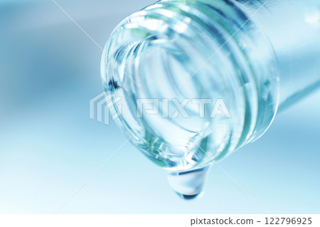 Drops of water spilling from a glass bottle 122796925
