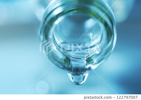 Drops of water spilling from a glass bottle Drops of water spilling from a glass bottle 122797007