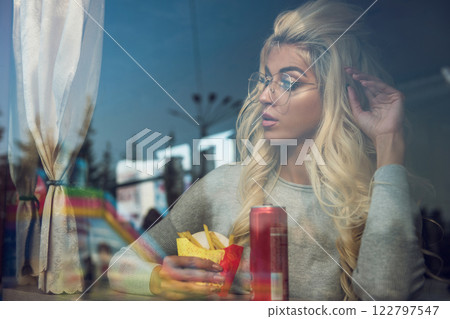 Stylish Woman Eating Snack 122797547