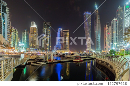 Panoramic night view of Dubai Marina skyline with waterfront reflections 122797618