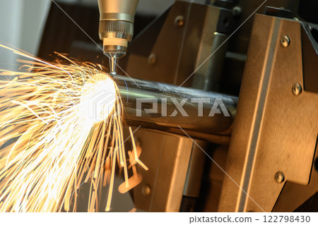 Close up scene the fiber laser cutting machine cut the stainless steel tube and sparkling light. 122798430
