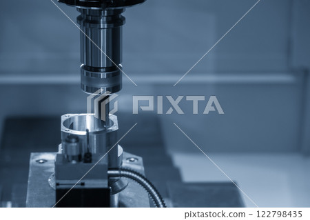 The CNC milling machine chamfer cutting aluminum part by chamfer tool in the light blue scene. The CNC milling machine chamfer cutting aluminum part by chamfer tool in the light blue scene. 122798435