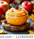 Homemade applesauce in small glass bowls with organic golden delicious apples and cinnamon. 122800088