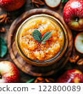 Homemade applesauce in small glass bowls with organic golden delicious apples and cinnamon. 122800089