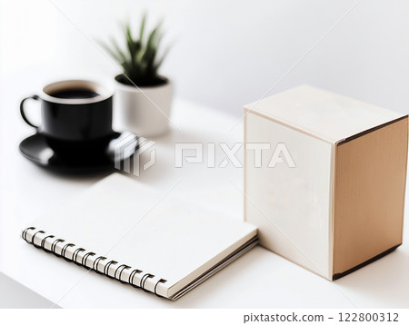 Minimalist workspace with a black coffee cup, a spiral notebook, a wooden cube, and a small potted plant 122800312