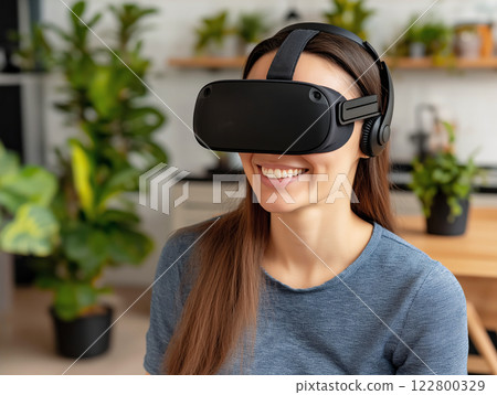 Smiling woman wearing a black virtual reality headset in a modern home environment Smiling woman wearing a black virtual reality headset in a modern home environment 122800329