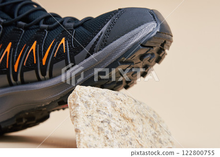 Black Hiking Boot on Small Rocks in Studio 122800755