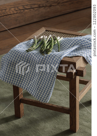 Fresh asparagus on rattan stool with linen tea towel. Healthy lifestyle concept 122802093