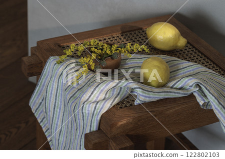 Fresh lemons and yellow wild flowers on wood rattan stool. Home decoration concept 122802103