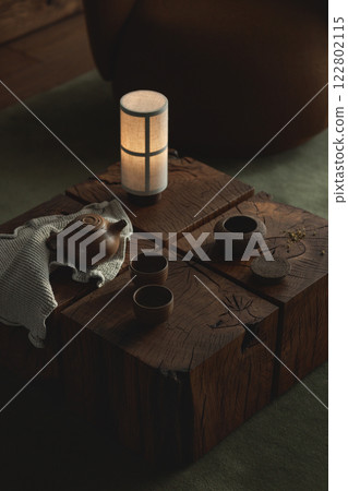 Tea drinking in wabi sabi Japanese style features brown clay cups and a teapot on a wooden solid oak tea table Tea drinking in wabi sabi Japanese style features brown clay cups and a teapot on a wooden solid oak tea table 122802115