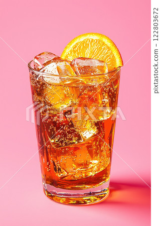 Aperol Spritz cocktail with ice and orange slices on pink background 122803672
