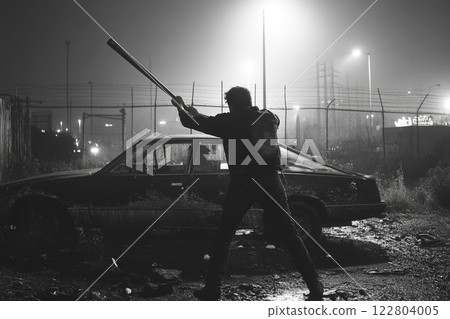 Hooligan attacking parked car with a bat in an urban environment at night Hooligan attacking parked car with a bat in an urban environment at night 122804005