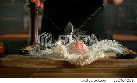 Freeze Motion of Falling Raw Chicken Leg into Flour . Closeup of Meat Preparation 122804291