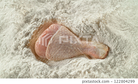 Freeze Motion of Falling Raw Chicken Leg into Flour . Filmed on High Speed Cinema Camera , 1000 fps . Closeup of Meat Preparation Freeze Motion of Falling Raw Chicken Leg into Flour . Filmed on High Speed Cinema Camera , 1000 fps . Closeup of Meat Preparation 122804299