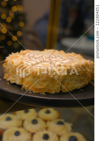 Beautiful black white hazelnut esterhazy cake topped almond slices on black plate on countertop elegant gourmet dessert rich layers flavor luxury pastry sweet indulgence sophisticated confection 122804851