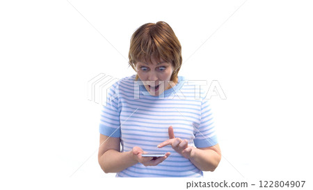 A young woman looks at her phone with a joy and astonished expression 122804907