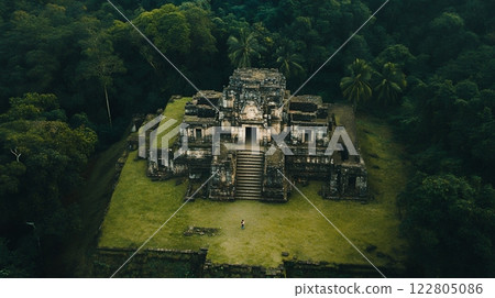 Aerial view of an ancient temple hidden within a dense jungle, showcasing historical architecture 122805086