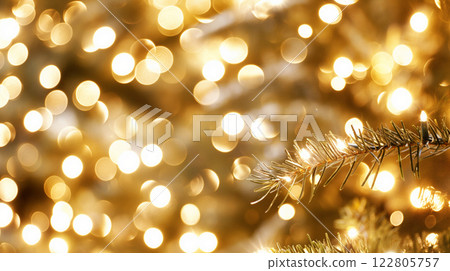 Christmas tree branch illuminating golden bokeh lights background 122805757