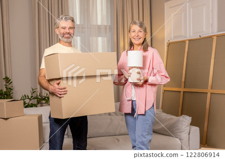 Senior family unpacking stuff in living room of their new apartment Senior family unpacking stuff in living room of their new apartment 122806914