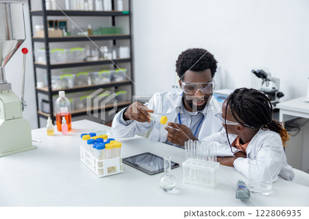Male teacher of science showing to a school girl how to use vacutainers 122806935