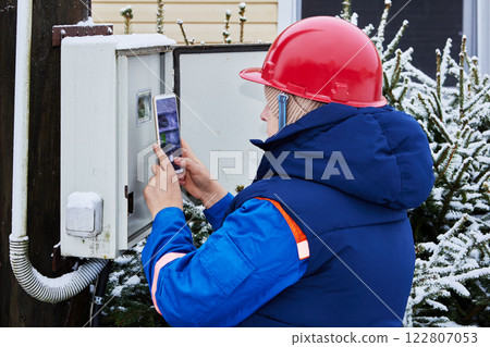 Customer field representative inspects an electricity meter for a routine check. Customer field representative inspects an electricity meter for a routine check. 122807053