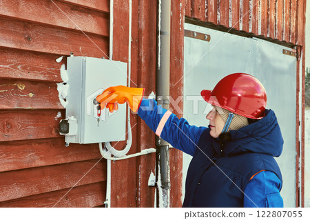 Utility field representative works on an outdoor consumer unit. 122807055