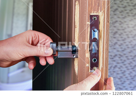 Door lock installer setting up mortice deadlock in home. Door lock installer setting up mortice deadlock in home. 122807061