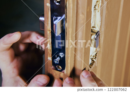 Worker ensuring correct alignment of mortise lock mechanism. Worker ensuring correct alignment of mortise lock mechanism. 122807062