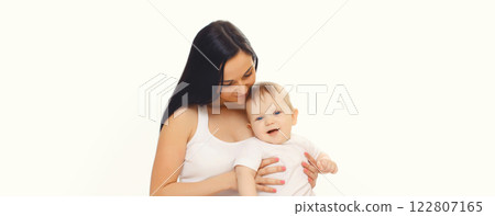 Happy smiling young mother playing with cute baby sitting together on the floor on white background Happy smiling young mother playing with cute baby sitting together on the floor on white background 122807165