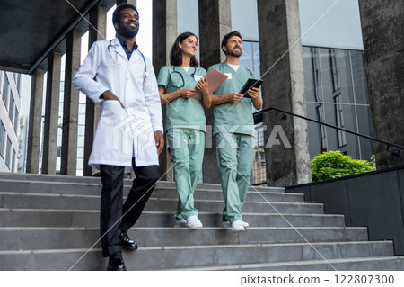 Group of doctors in lab coats feeling confident and looking determined Group of doctors in lab coats feeling confident and looking determined 122807300
