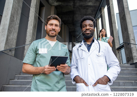 Two male doctors on the clinic stairs looking confident and determined 122807319