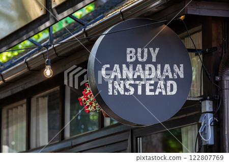 BUY CANADIAN INSTEAD. Round, black sign onn teh wall of the house BUY CANADIAN INSTEAD. Round, black sign onn teh wall of the house 122807769