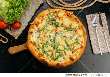 Gourmet four-cheese pizza with arugula, served on a wooden board in a stylish restaurant setting Gourmet four-cheese pizza with arugula, served on a wooden board in a stylish restaurant setting 122807796