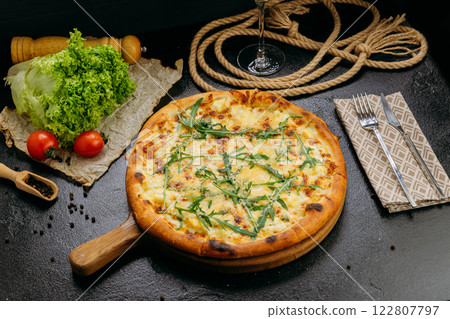 Gourmet four-cheese pizza with arugula, served on a wooden board in a stylish restaurant setting Gourmet four-cheese pizza with arugula, served on a wooden board in a stylish restaurant setting 122807797