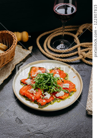 Roasted bell pepper carpaccio with arugula, feta cheese, pine nuts, and pesto, in gourmet style Roasted bell pepper carpaccio with arugula, feta cheese, pine nuts, and pesto, in gourmet style 122807815