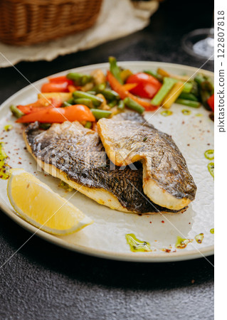 Grilled sea bream fillet with vegetables and lemon, plated with elegant garnish, fine dining style 122807818