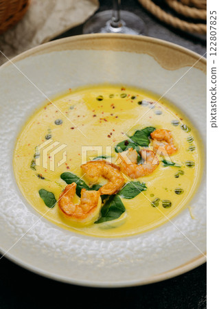 Creamy shrimp soup with spinach, garnished with chili flakes and herb oil, served in a gourmet style 122807825