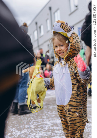 5-year-old girl in a tiger costume at a carnival in Germany, full of joy and excitement. 122807957
