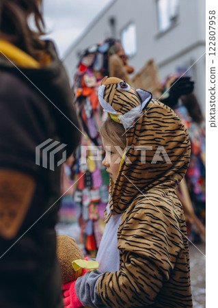 5-year-old girl in a tiger costume at a carnival in Germany, full of joy and excitement. 122807958