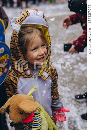 5-year-old girl in a tiger costume at a carnival in Germany, full of joy and excitement. 122807961